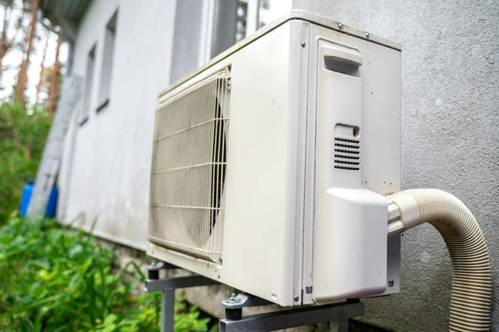 Professional Ductless Heat Pumps in King & Pierce Counties | Trusted heat pump and air conditioning in king & pierce county | Heat pump outside of residential house Trusted heat pump and air conditioning in king & pierce county | Heat pump outside of residential house